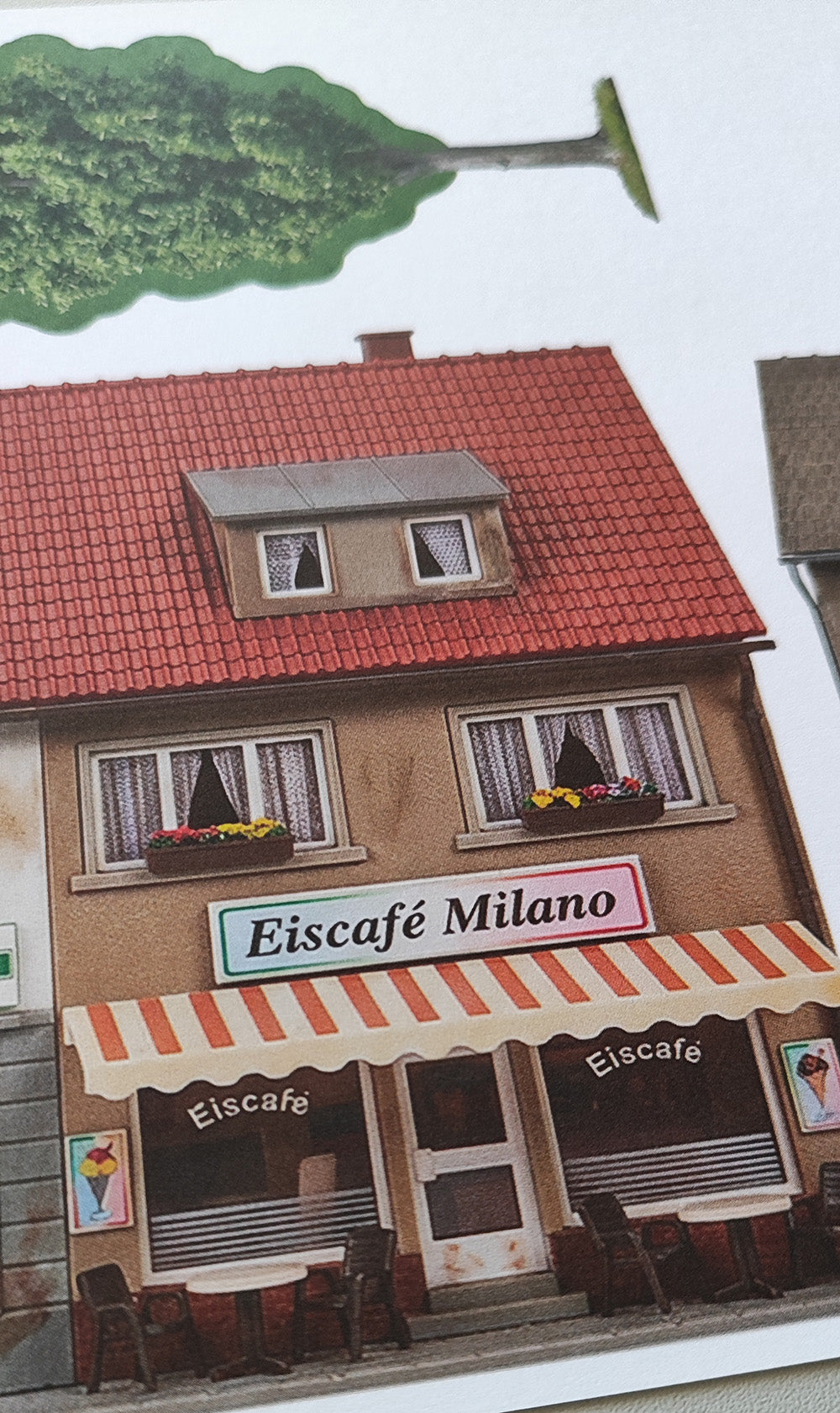 Modellbahnhintergrund zweigeschossige Gebäude Apotheke und Eiscafe Milano und Lebensmittelgeschäft und Baum H0 1zu87 KM00000086